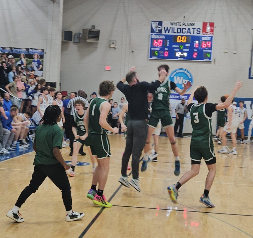 Faith Christian coach Cory Hughes does a leaping chest bump with Conner Richerzhagen after the Lions beat White Plains on Friday. (Photo by Joe Medley)